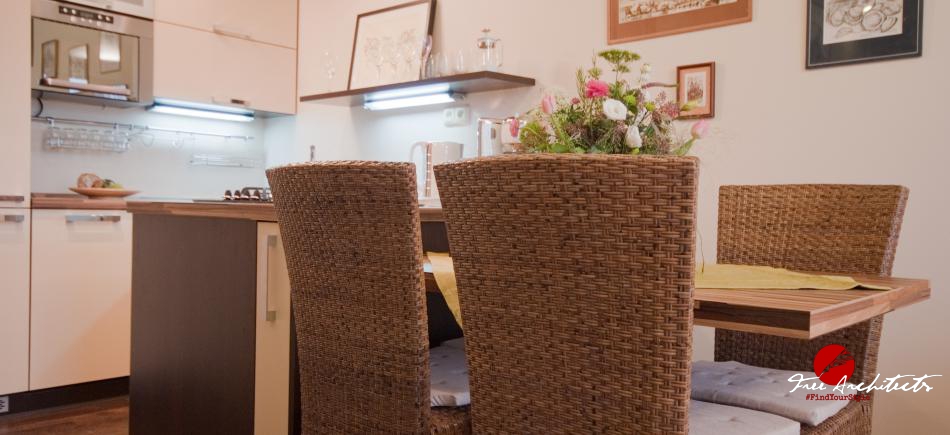 Ratanové židle s bavlněnými polštáři a jídelní stůl s jednou nohou